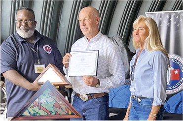 LAWRENCE RHONE, left, receives his ….